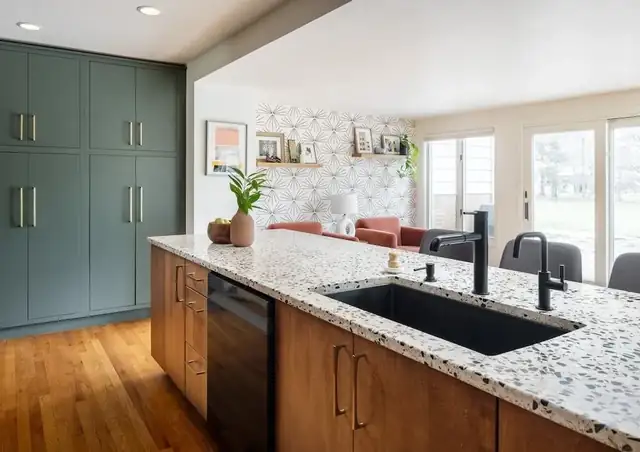 Kitchen update with green full-height cabinets, speckled granite island, black sink and faucet, and wood base cabinets