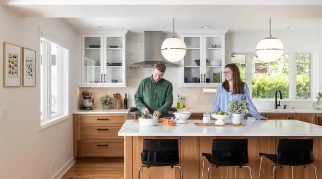 Ann Arbor kitchen remodel with white glass-front upper cabinets, wood island with black stools and globe pendant lights