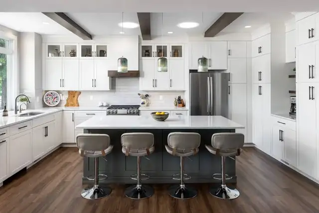 Remodeled Ann Arbor kitchen with white shaker cabinets, dark-base island with four gray stools and exposed ceiling beams